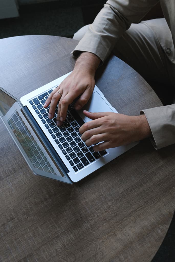 hands typing on a laptop keyboard