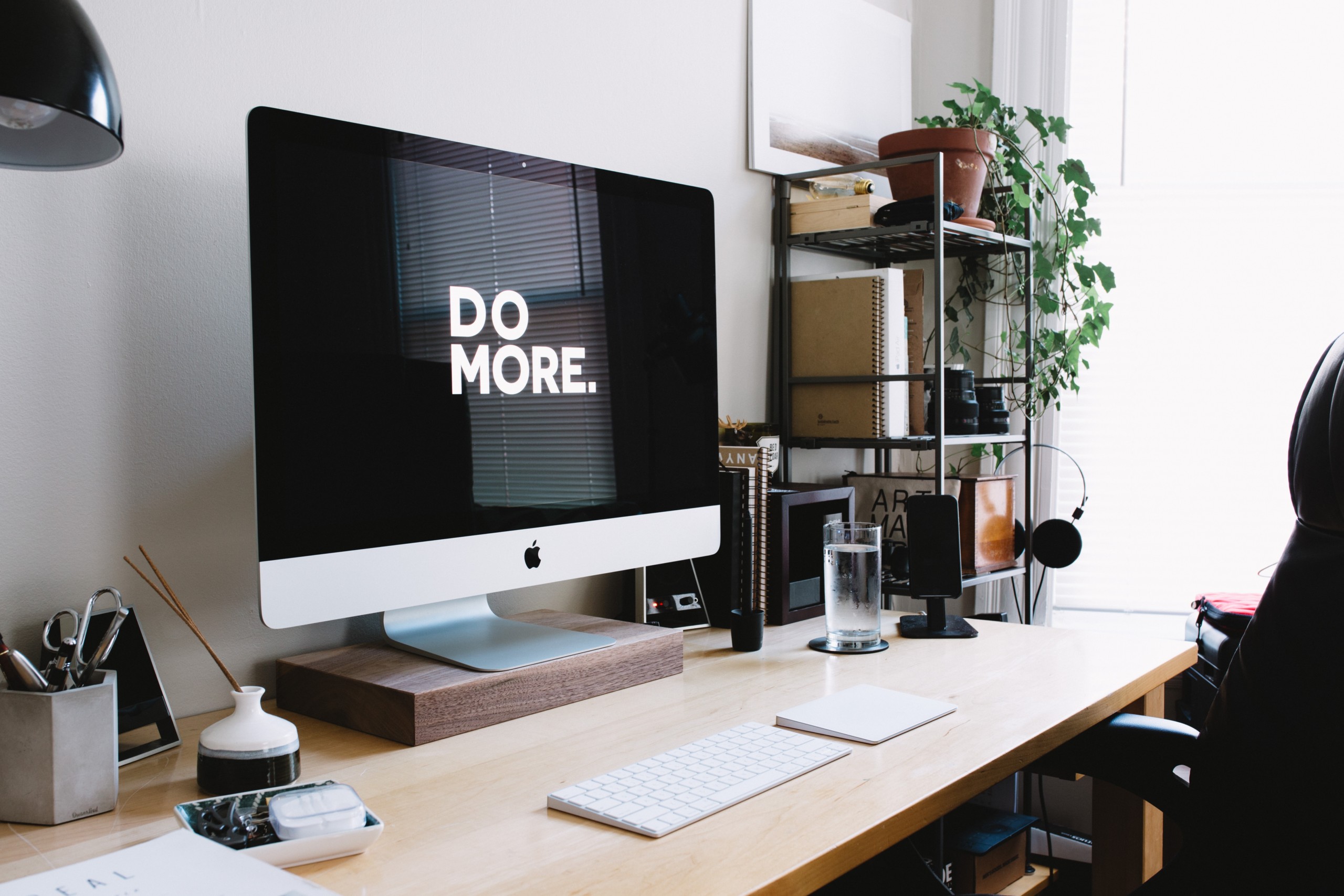 desk with desktop computer and wallpaper "do more"